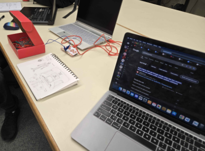 Picture of laptop, sketches, and early makeymakey board on table.